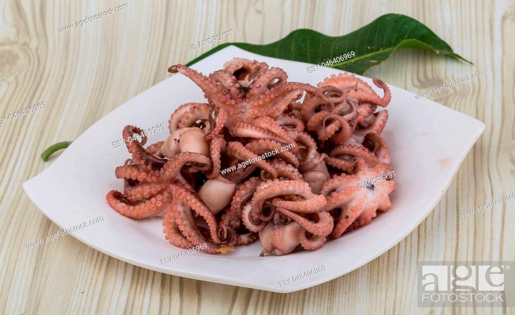 Stock Photo: Boiled octopus in the bowl on wooden background.
