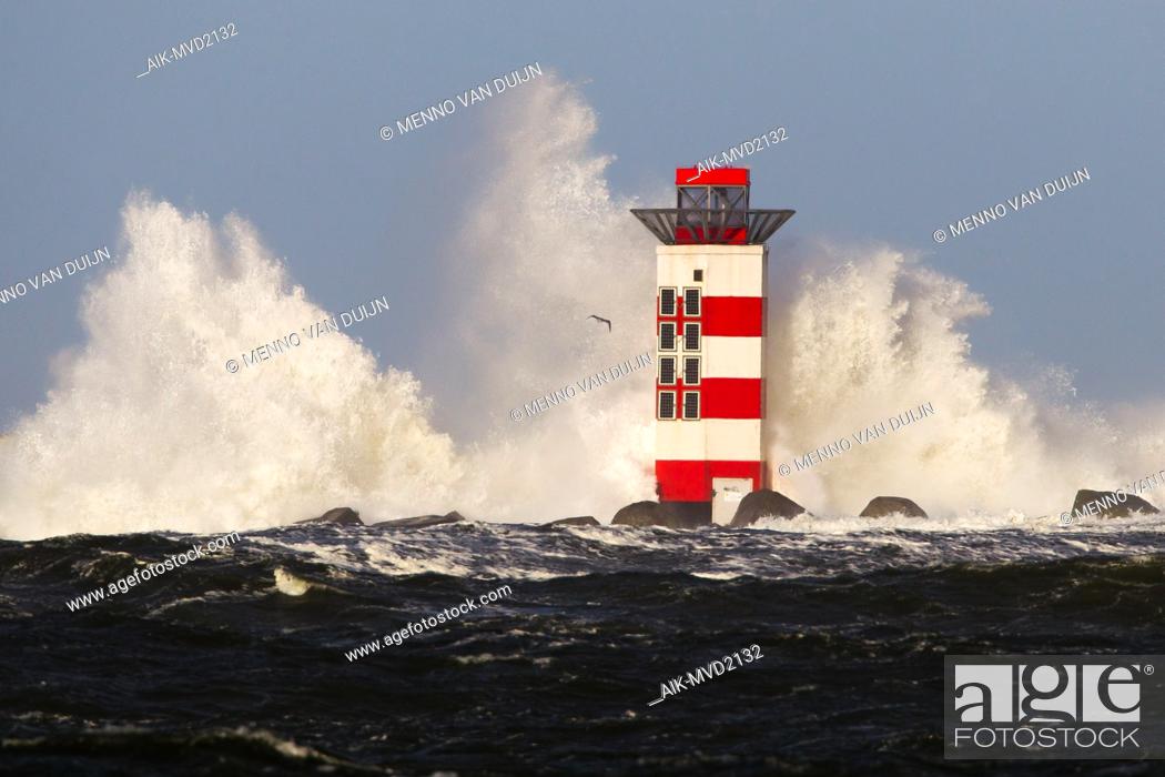 Stock Photo: Big waves crashing against the lighthouse at the tip of the pier of Ijmuiden, Netherlands, during severe storm over the North Sea.