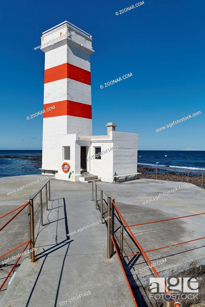 Stock Photo: Small lighthouse on the tip of a peninsula.