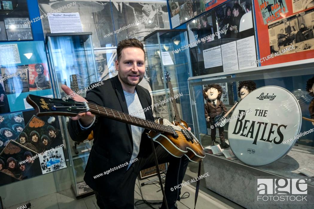 Photo de stock: PRODUCTION - 07 April 2022, Saxony-Anhalt, Halle (Saale): Beatles Museum director Martin Schmidt shows a replica of Paul McCartney's 1962 bass guitar.