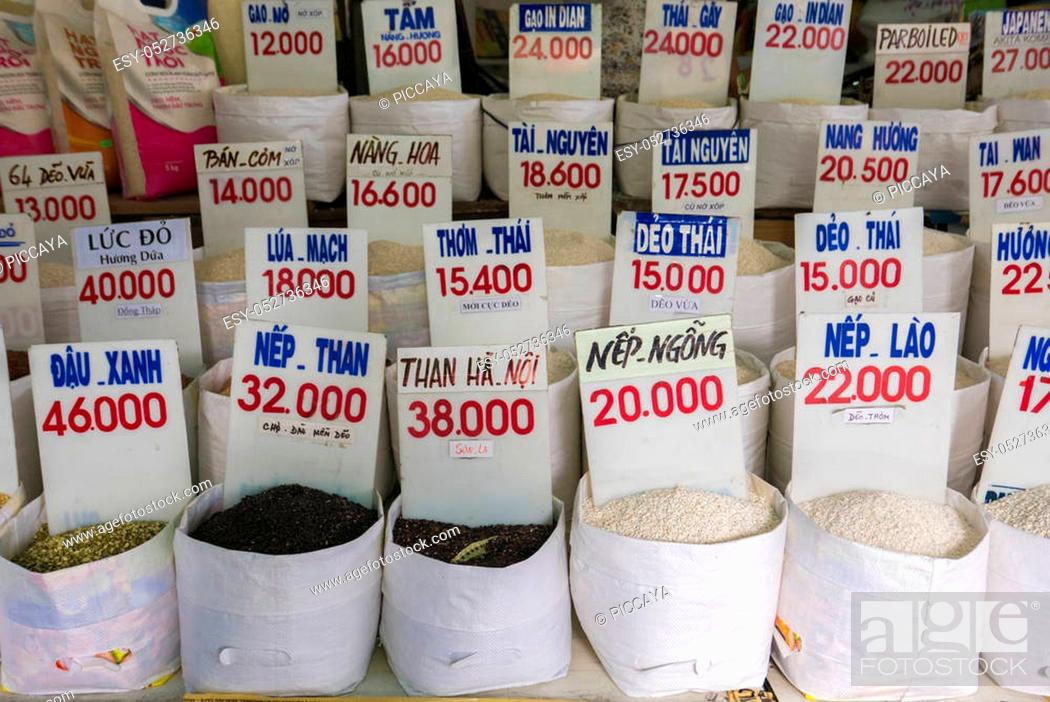 Stock Photo: Various bags of rice in a local outdoor market in Ho Chi Minh with price. The names of different rice is written in Vietnamese over the prices.