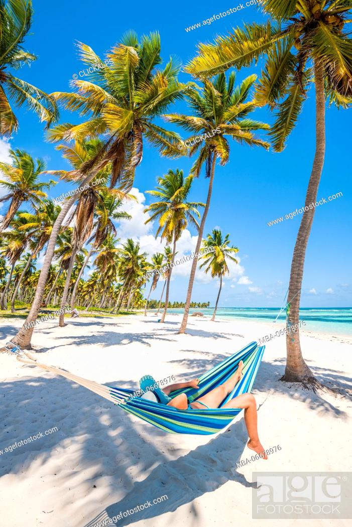 Stock Photo: Canto de la Playa, Saona Island, East National Park (Parque Nacional del Este), Dominican Republic, Caribbean Sea. Woman relaxing on a hammock on the beach (MR).