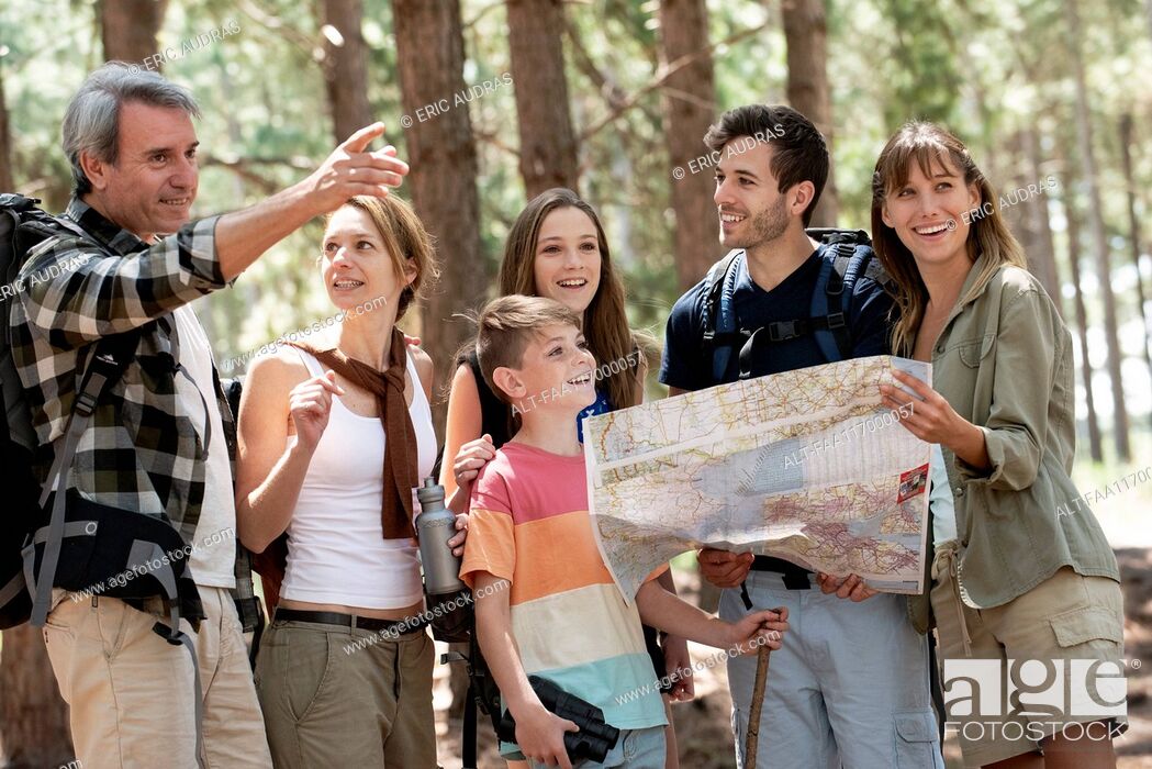 Imagen: Family reading a map while standing in forest.