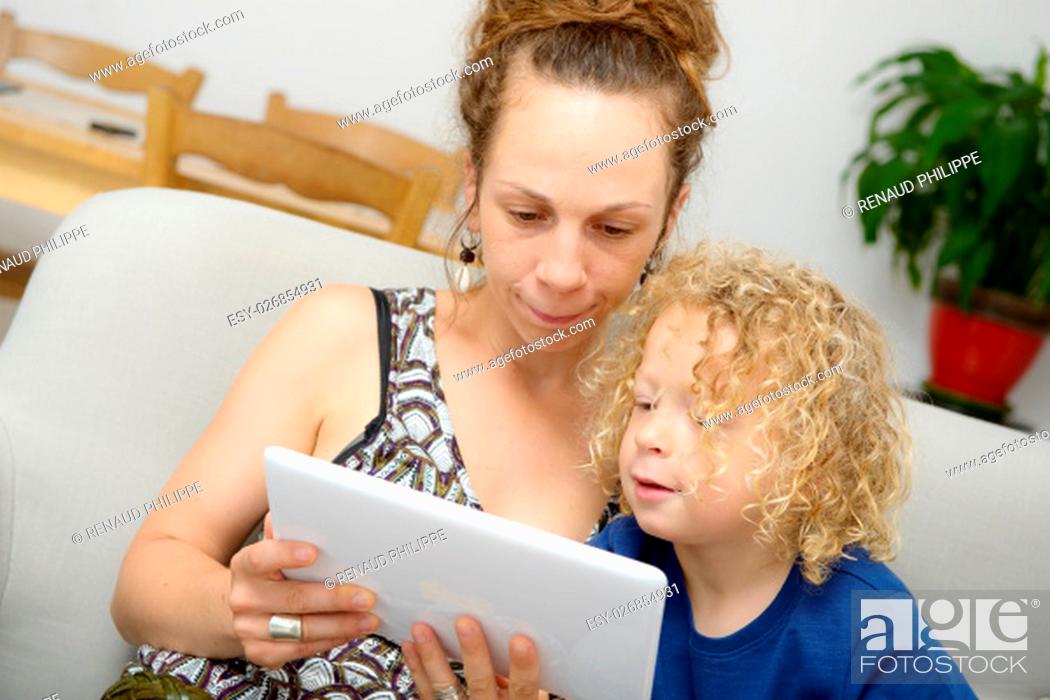 Imagen: a blond child and her mom uses a digital tablet.