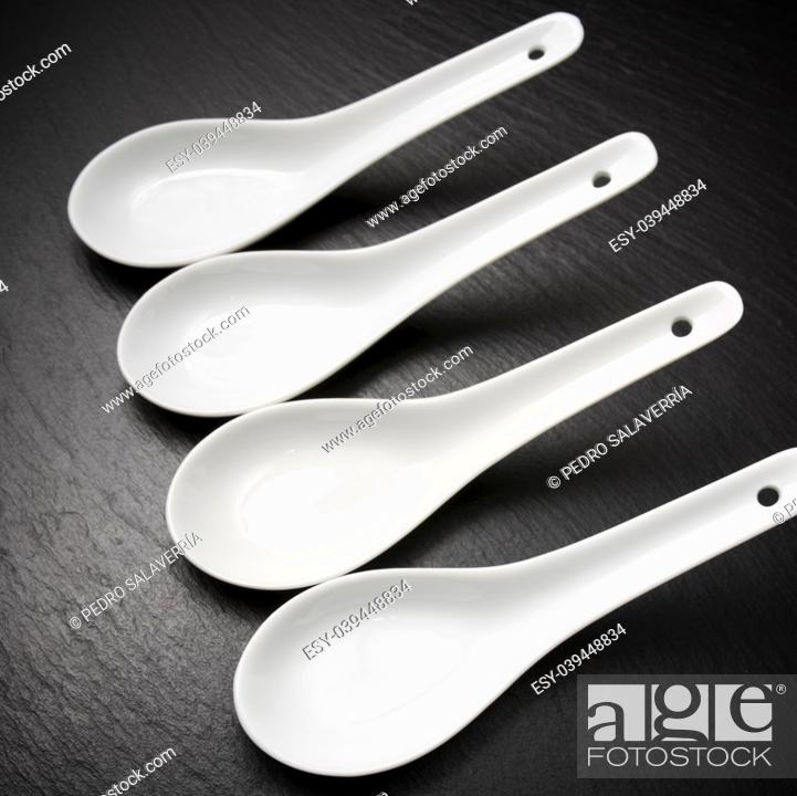 Stock Photo: four small white spoons on a table slate.
