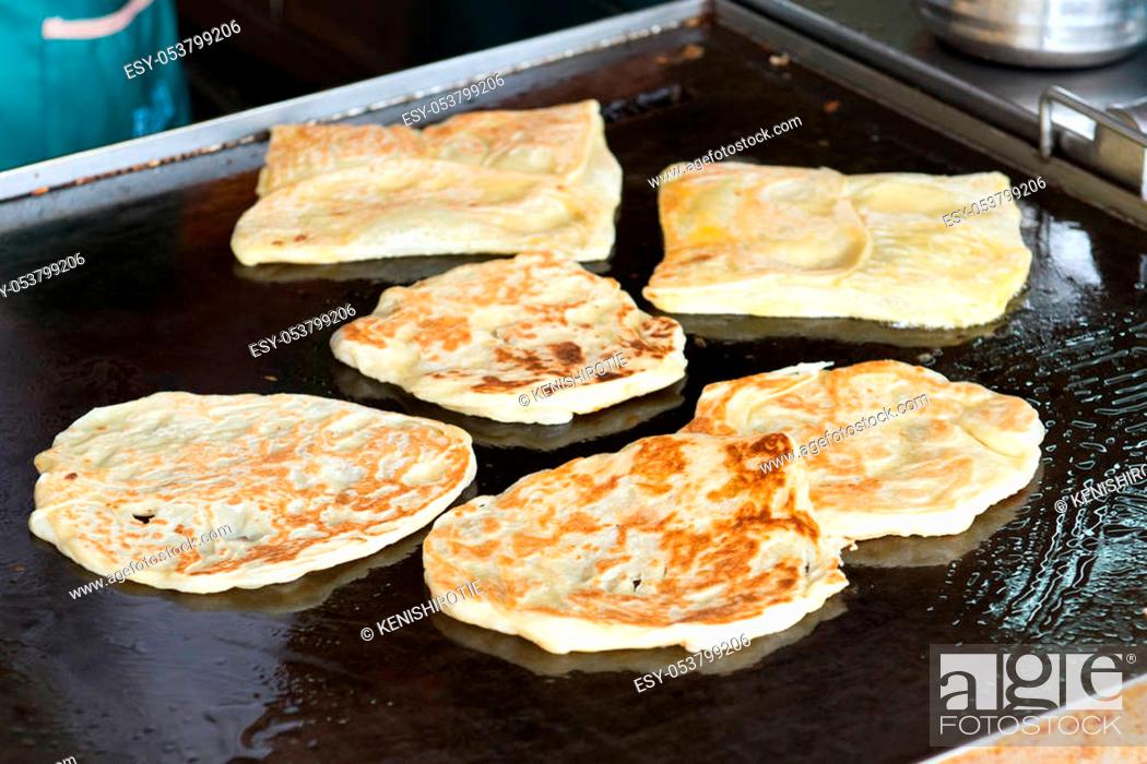 Stock Photo: Close up of pan fry Indian flat bread, roti canai in the hawker stall.