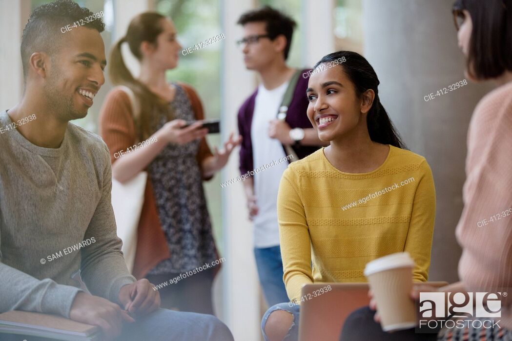 Stock Photo: Smiling college students studying drinking coffee.