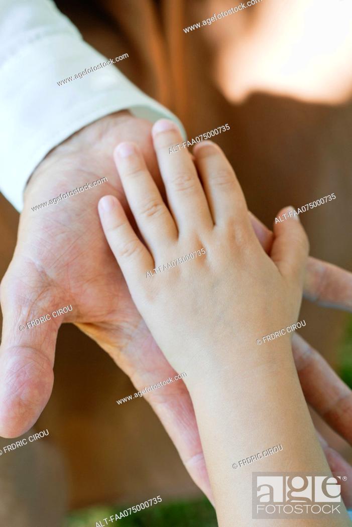 Stock Photo: Little girl and grandmother's hands touching.