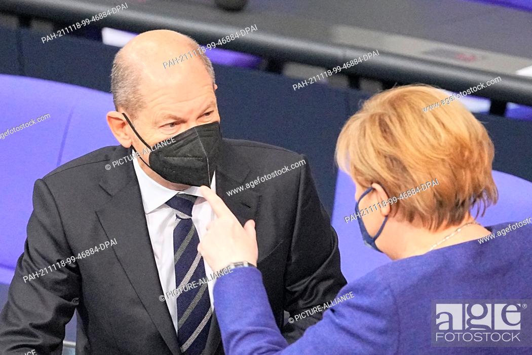 Stock Photo: 18 November 2021, Berlin: Olaf Scholz (SPD), Executive Federal Minister of Finance, in conversation with Chancellor Angela Merkel (CDU) during the session of.