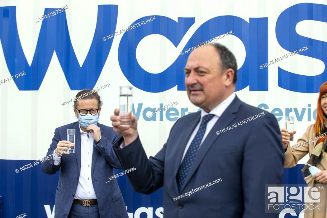 Stock Photo: Belgian businessman Marc Coucke and Walloon Vice-Minister President Willy Borsus drink a glass of water at the opening of a wastewater recycling facility on the.