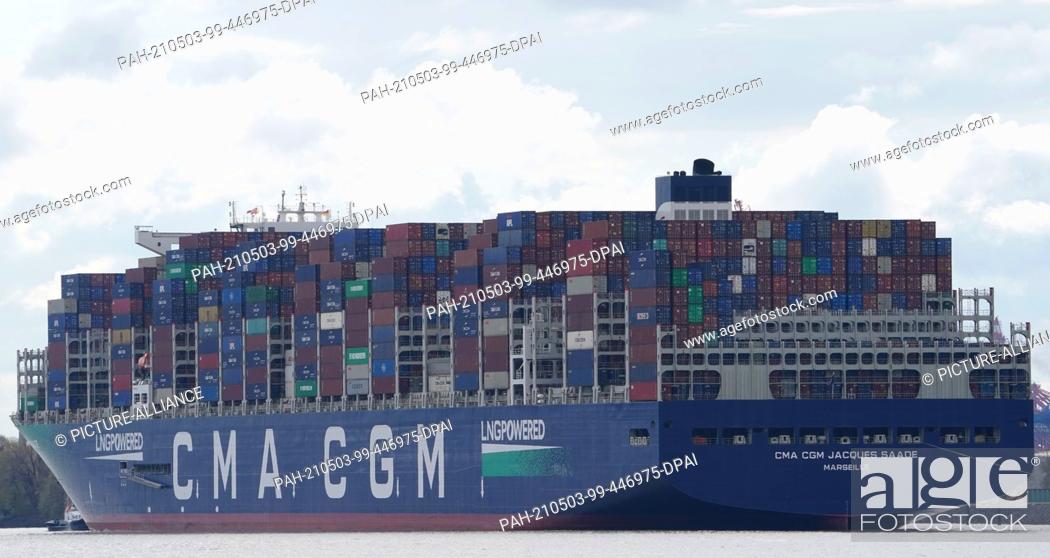 Stock Photo: 03 May 2021, Hamburg: The huge container ship ""CMA CGM Jacques Saade"" of the shipping company CMA CGM sails on the Elbe past the Teufelsbrück jetty towards.