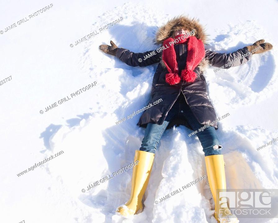 Stock Photo: USA, New Jersey, Jersey City, young woman doing snow angel.