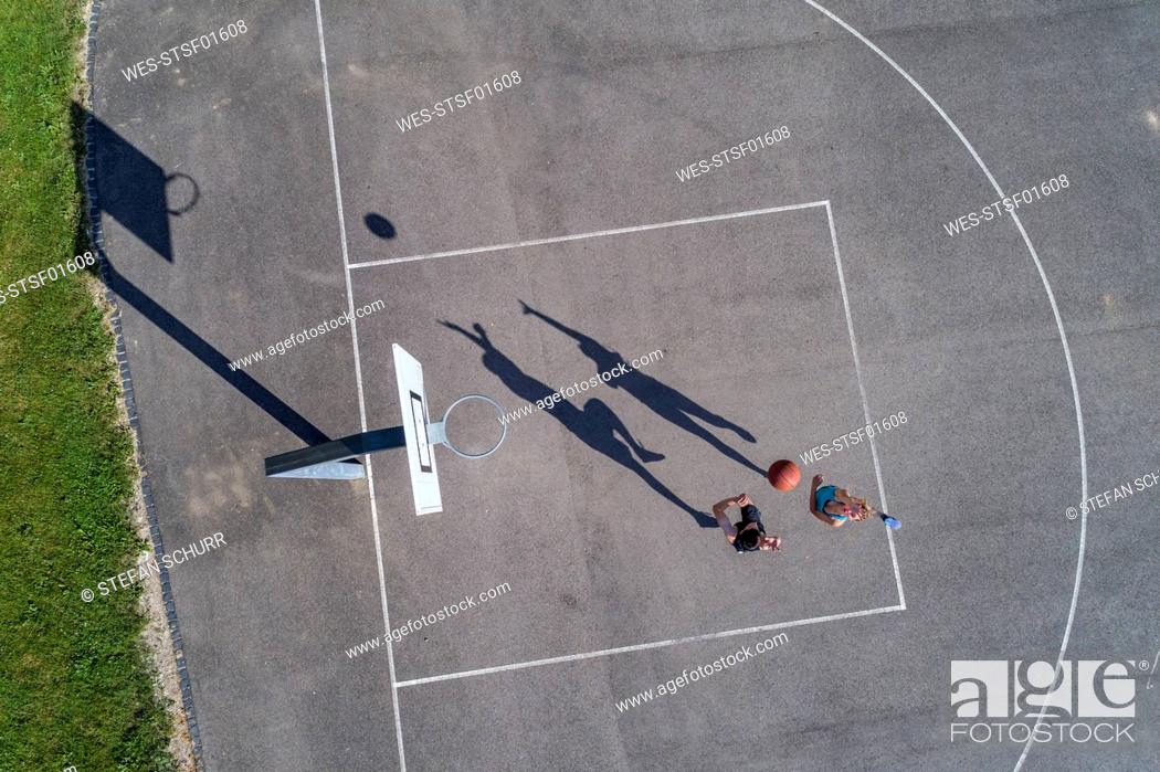 Stock Photo: Young man and woman playing basketball, aerial view.