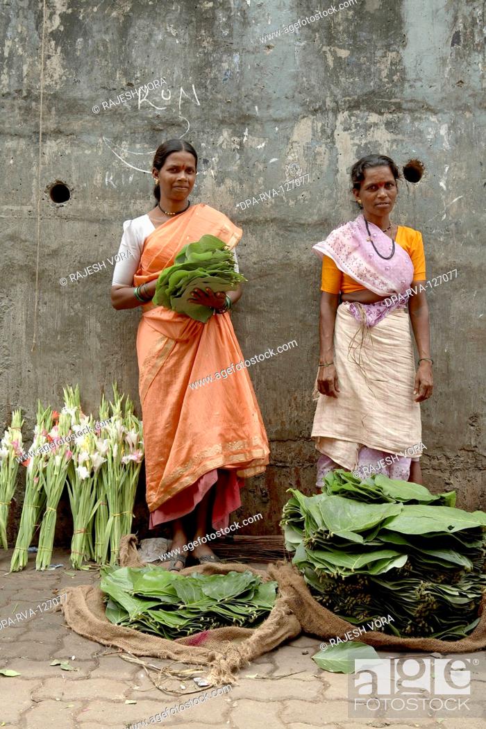 Stock Photo: Women hawkers selling leaves to pack flowers for offering to Gods ;  Mumbai Bombay ; Maharashtra ; India.