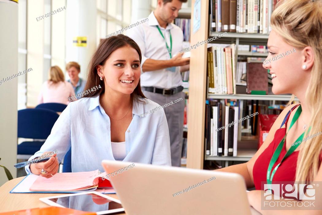 Stock Photo: Two Female College Students Studying In Library Together.