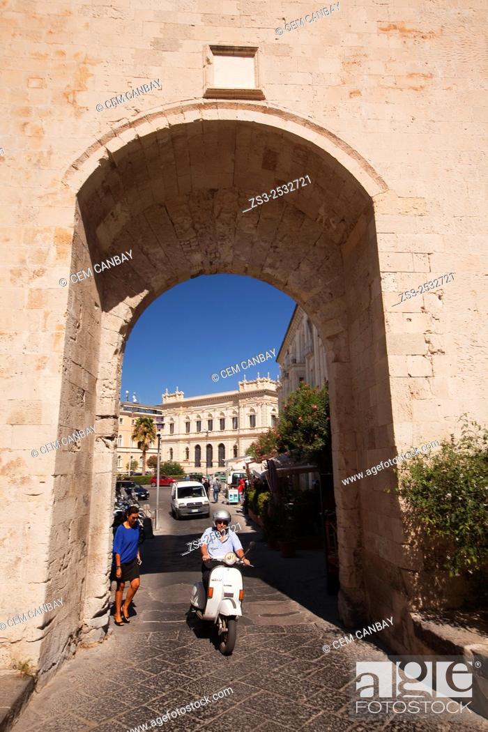 Stock Photo: Motorcyclist driving through the Porta Marina gate in Ortygia Island, Syracuse, Sicily, Italy, Europe.