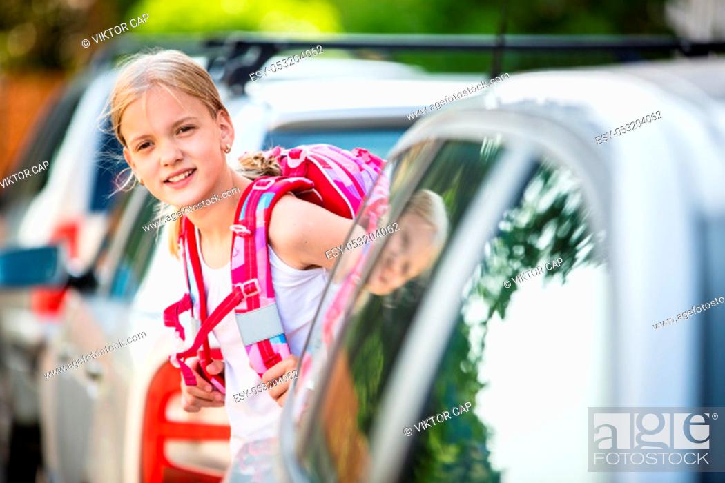 Stock Photo: Cute little girl going home from school, looking well before crossing the street.