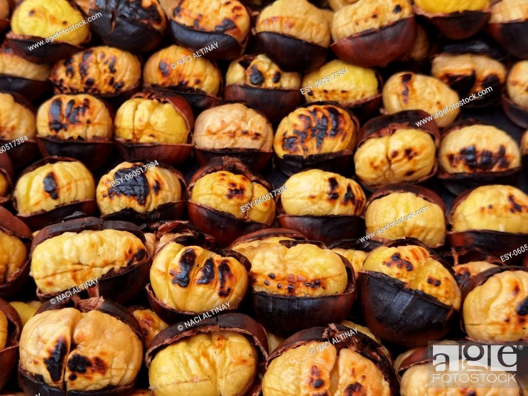 Imagen: Roasted chestnuts on hot charcoal. The skin has cracked open.