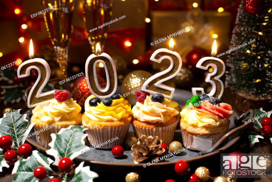 Photo de stock: Food tray with cupcakes new year candles and wineglasses.