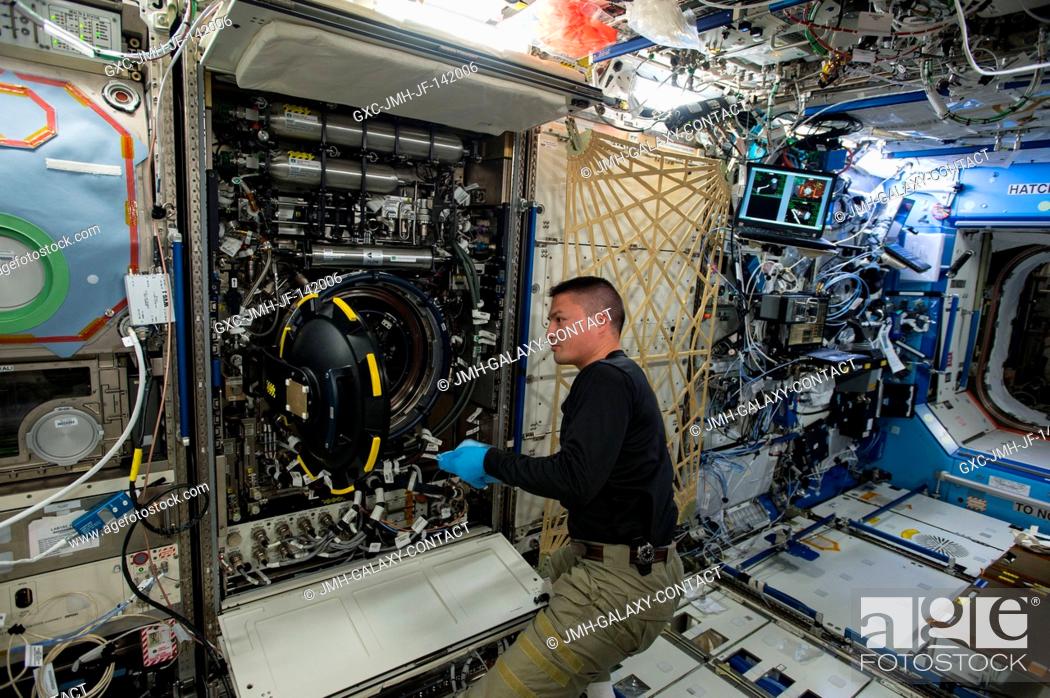 Stock Photo: NASA astronaut Kjell Lindgren replaces items inside the Multi-user Droplet Combustion Apparatus found inside the station's Combustion Integrated Rack (CIR.