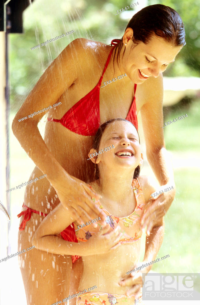 Stock Photo - Mother and daughter in bathing suits in outdoor shower.