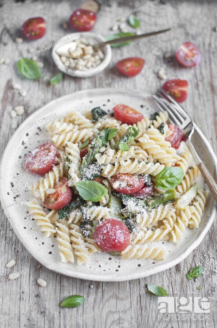 Stock Photo: Fusilli pasta with spinach, asparagus, tomatoes, basil, pine nuts and grated parmesan cheese.