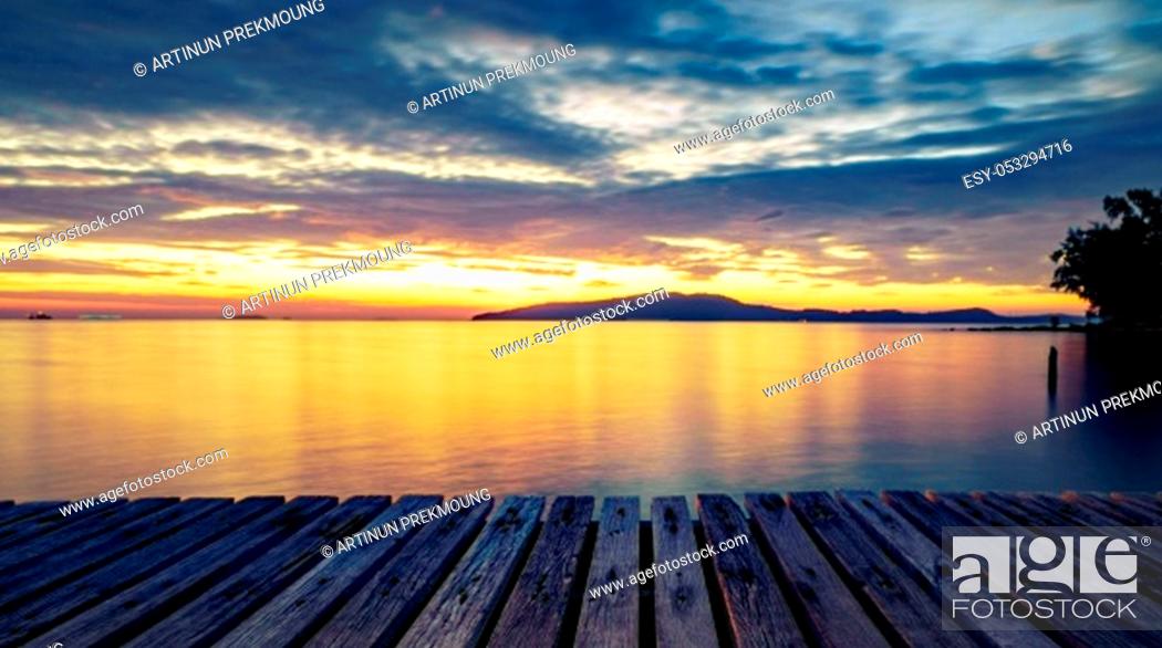 Stock Photo: Wood pier with sea and mountain at sunrise with beautiful golden sky in the morning and copy space use as background to display goods and product.