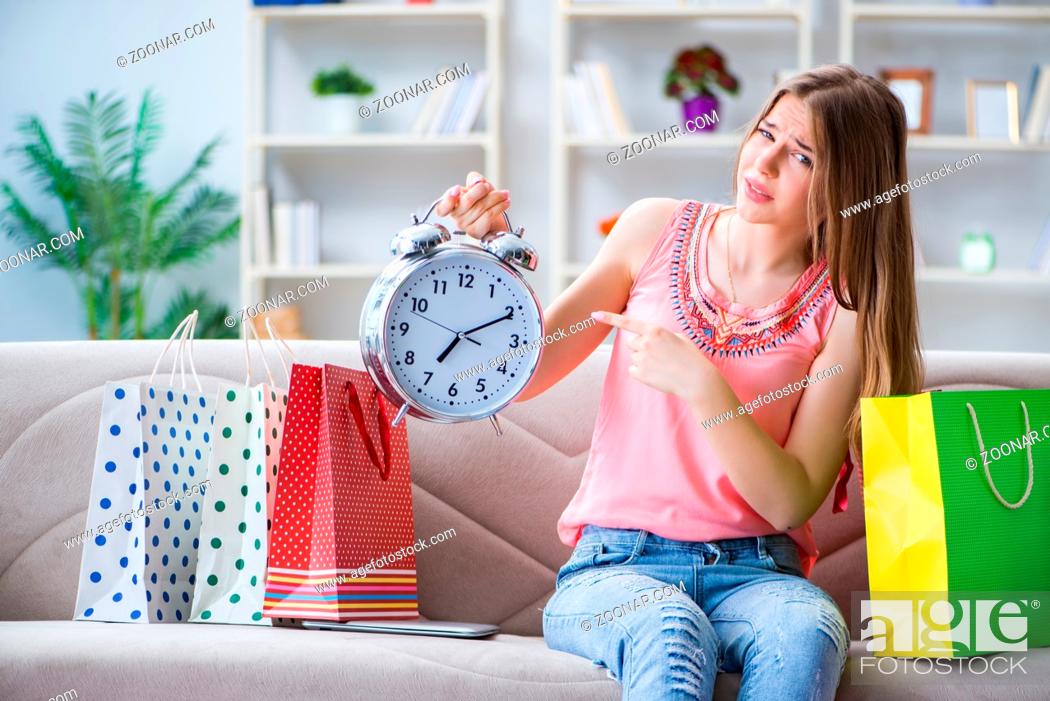 Stock Photo: Young woman with shopping bags indoors home on sofa.