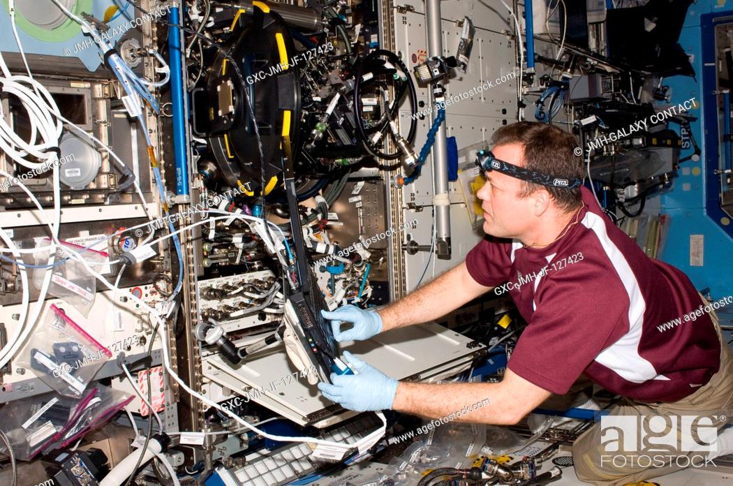 Stock Photo: NASA astronaut Ron Garan, Expedition 27 flight engineer, services the Combustion Integrated Rack (CIR) Multi-user Drop Combustion Apparatus (MDCA) in the.