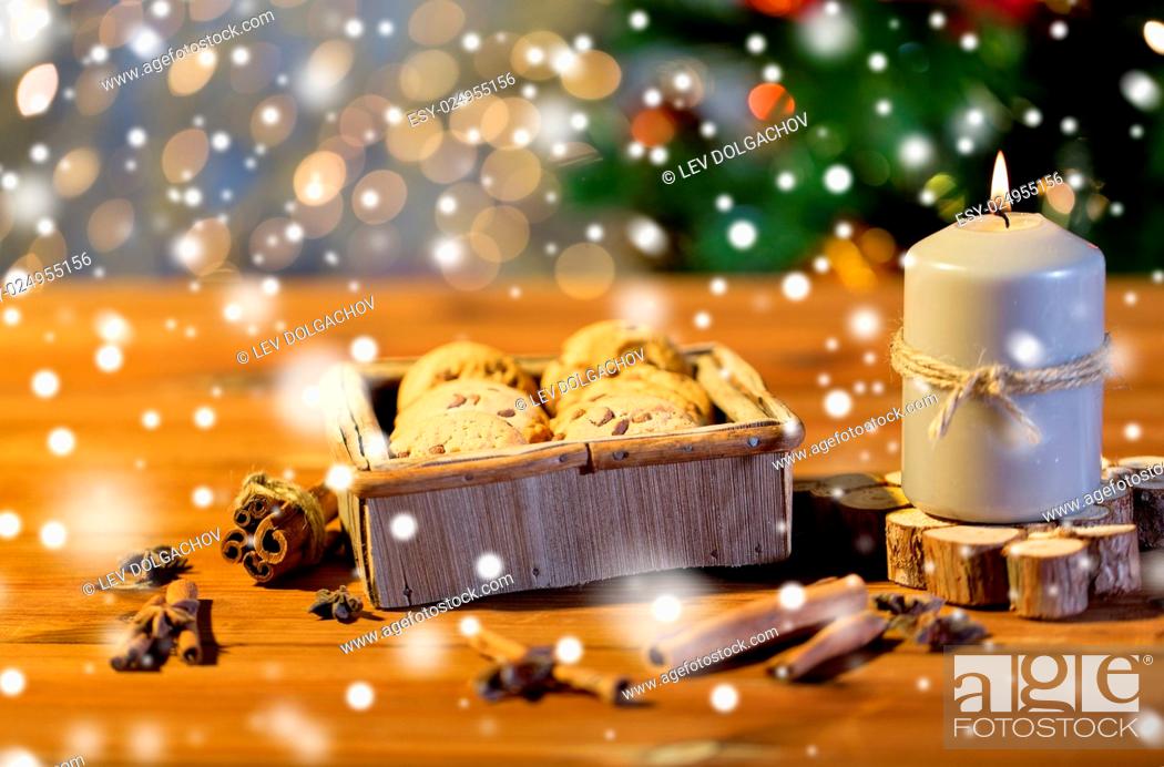 Stock Photo: christmas, holidays, food and baking concept - close up of oat cookies in wooden box and cinnamon on table over lights.