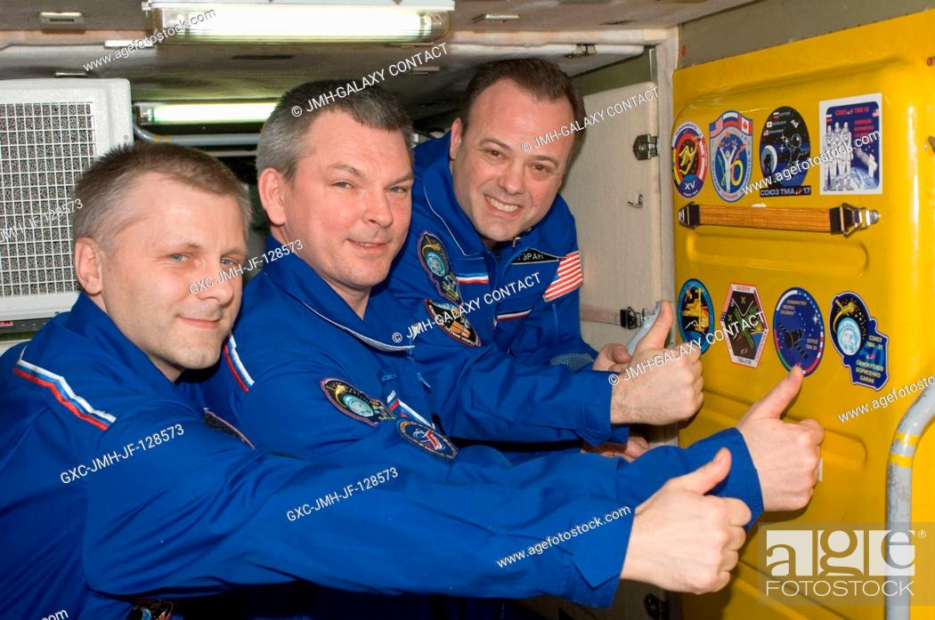 Stock Photo: In the Zarya Functional Cargo Block (FGB), Expedition 28 crew members add the Soyuz TMA-21 patch to the growing collection of insignias representing crews who.