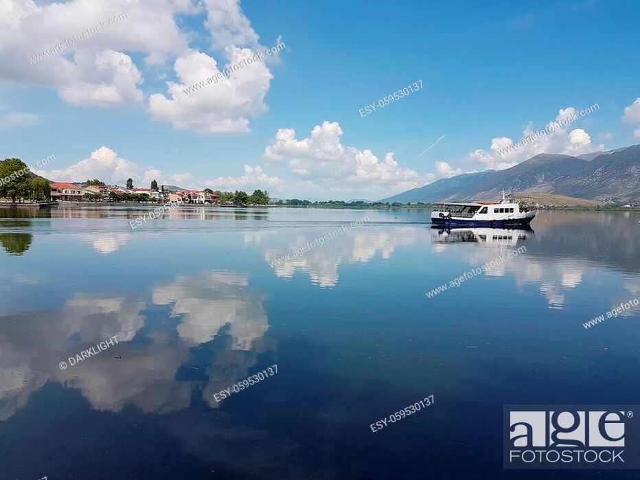 Stock Photo: Ioannina city and lake Pamvotis in spring season boat reflection of the clouds in the water green trees in greece.