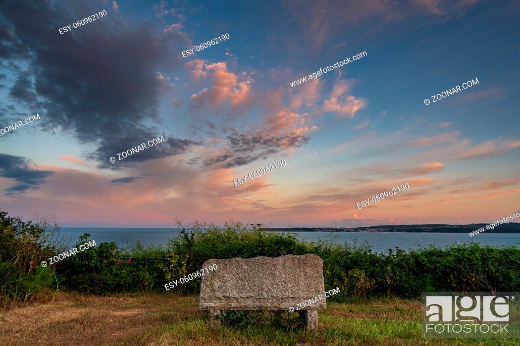 Stock Photo: Evening clouds over a bench in Daddyhole Cove, Torquay, Torbay, England, UK.