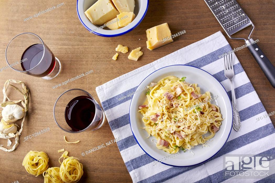 Stock Photo: Homemade pasta Carbonara with parmesan cheese and a glass of red wine.