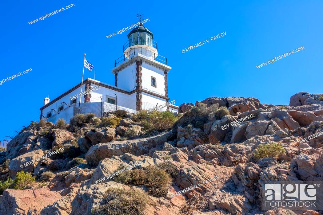 Stock Photo: Greece. Rocky mountain on a sunny day. Lighthouse building against the blue sky and national flag.