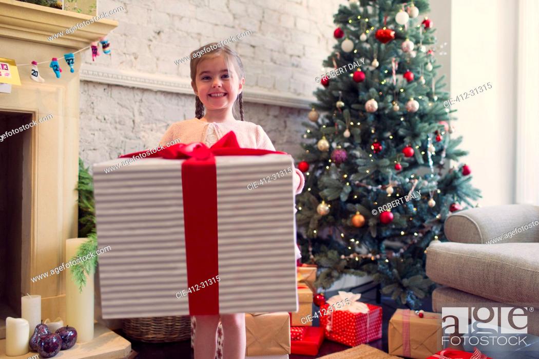 Stock Photo: Portrait enthusiastic girl holding large Christmas gift.