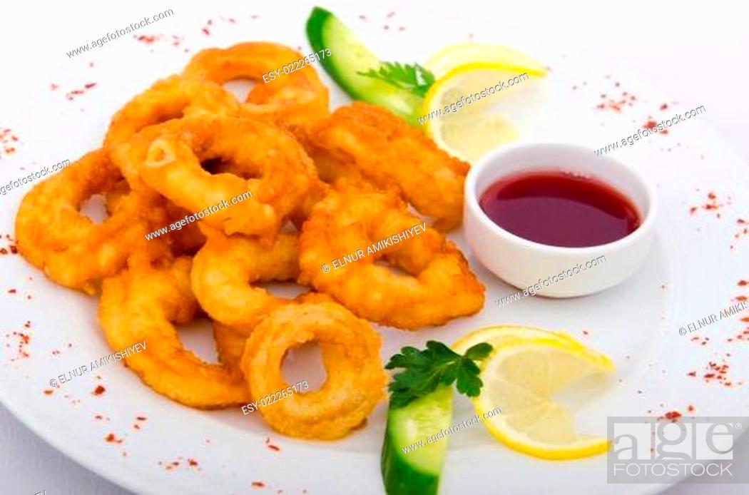 Stock Photo: Fried calamari rings served with sauce.