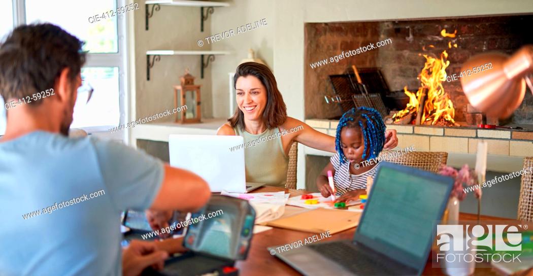 Stock Photo: Family working and coloring at dining table.