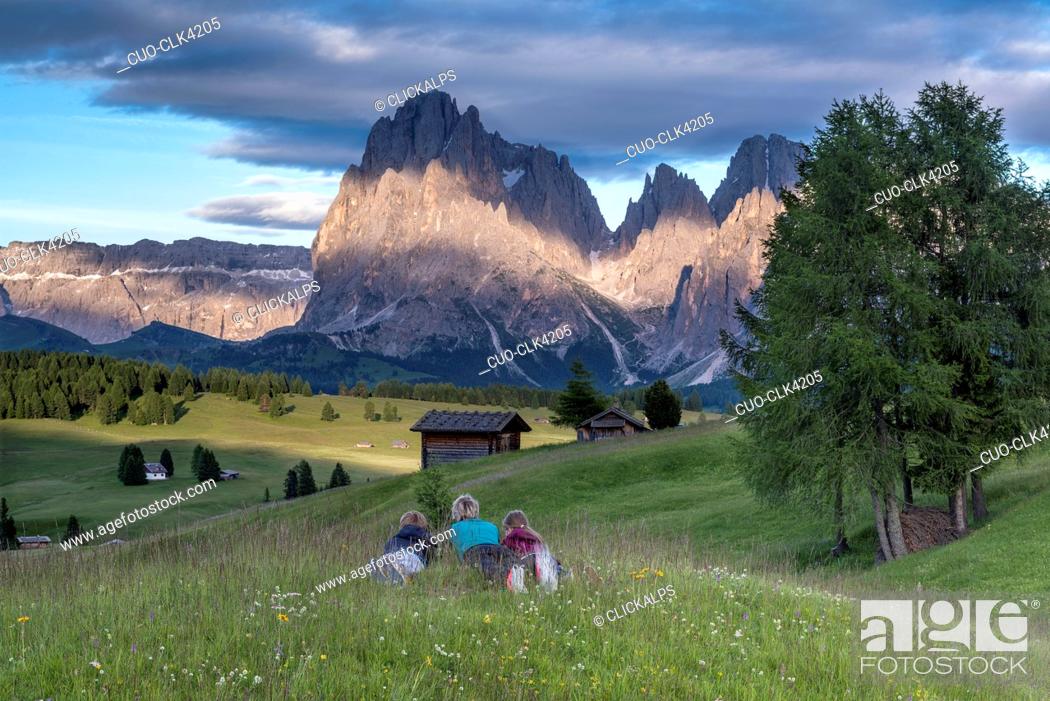 Stock Photo: Mountaineers on the Alpe di Siusi admire the alpenglow. In the background the Sella, Sassolungo/Langkofel and Sassopiatto/Plattkofel, Alpe di Siusi, Dolomites.