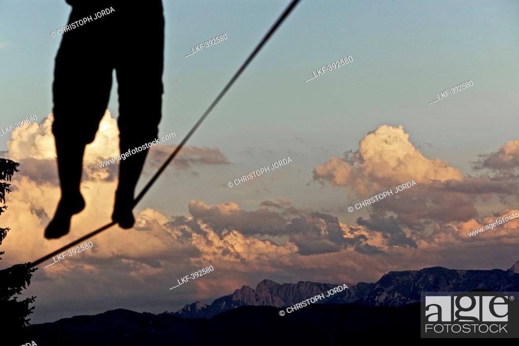 Stock Photo: Young man balancing on a longline at sunset, Auerberg, Bavaria, Germany, Europe.