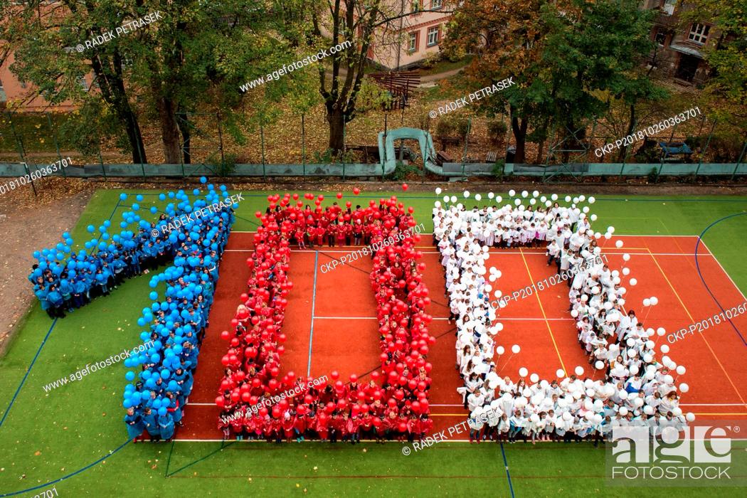 Stock Photo: 520 pupils and teachers of the Hus elementary school in Liberec, stand in the form of digit 100, dropped balloons in Czech national colors with the wish for the.