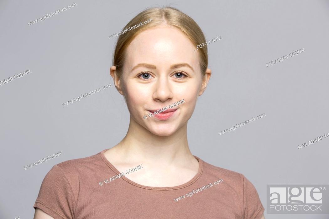Stock Photo: Portrait confident smiling young woman on gray background.