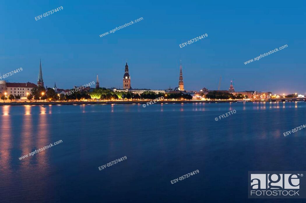 Stock Photo: Skyline of Riga seen across the river Daugava after the sunset. Three church towers in the picture are the Riga Dome cathedral, St.