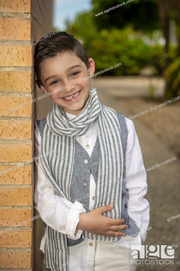 Photo de stock: Child poses for fashion leaning on corner, sympathetic and laughing.