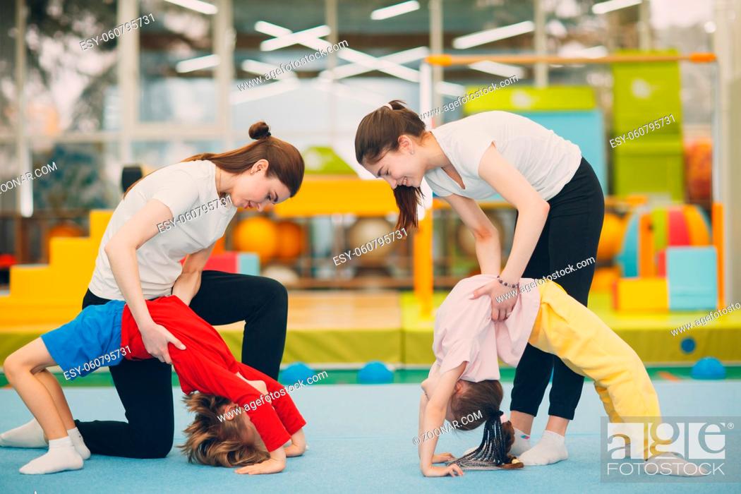 Stock Photo: Kids doing exercise bridge in gym at kindergarten or elementary school. Children sport and fitness concept.