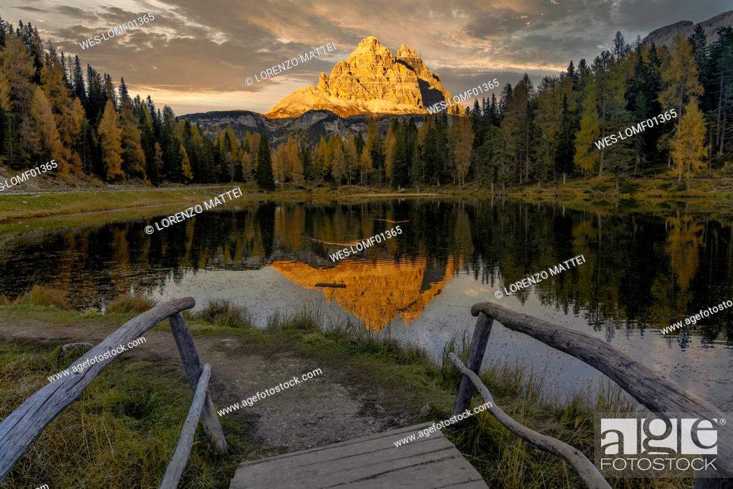 Stock Photo: Italy, Veneto, Wooden steps in front of Lake Antorno at dusk with Tre Cime di Lavaredo peaks in background.