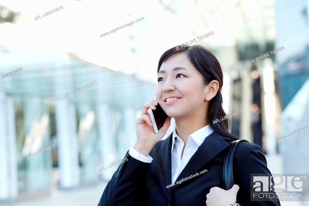 Stock Photo: Japanese young businesswoman on the phone downtown Tokyo.