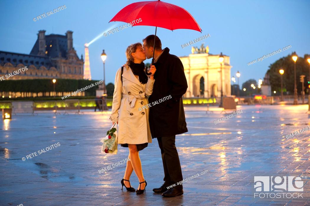 Caucasian couple kissing in rain at night near the Louvre, Stock Photo,  Picture And Royalty Free Image. Pic. BIM-BLD082354 | agefotostock