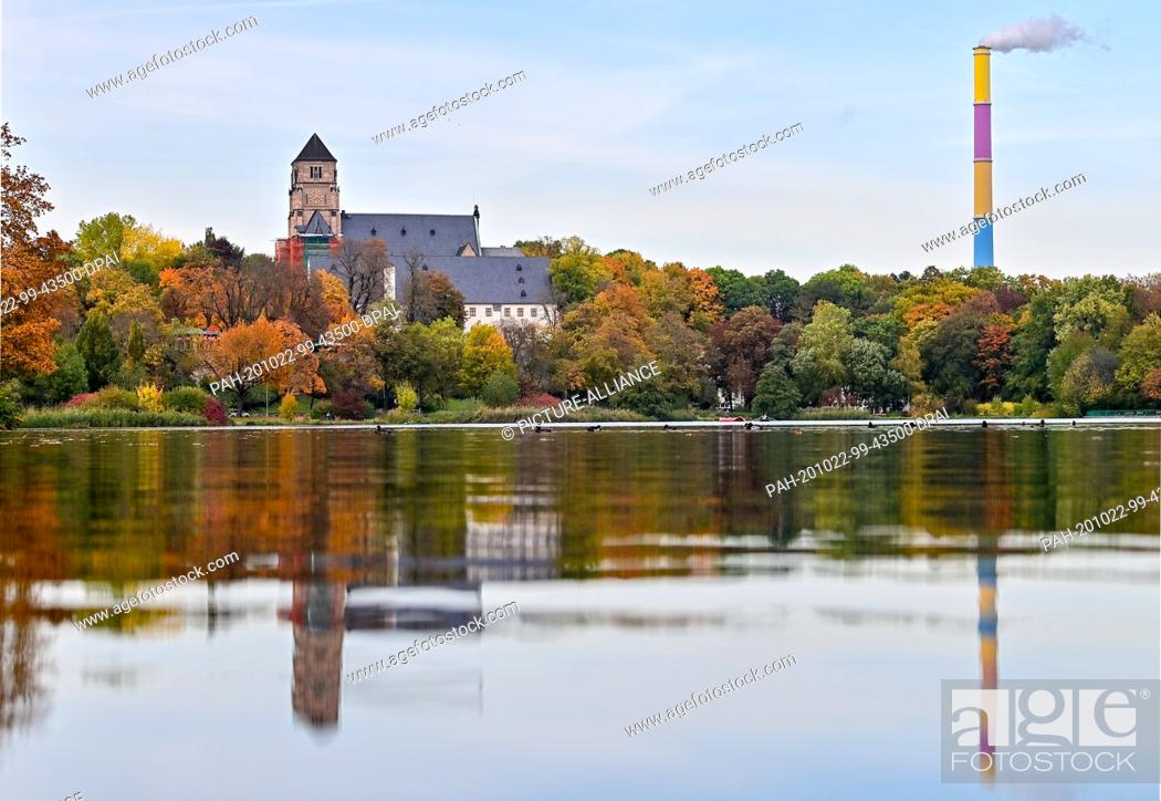Stock Photo: 22 October 2020, Saxony, Chemnitz: The castle church and the chimney of the thermal power station, designed by the French painter Daniel Buren.