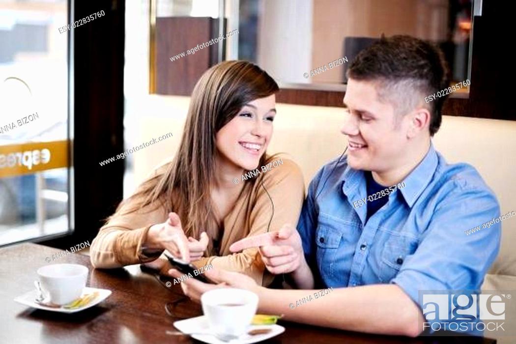 Stock Photo: Couple listening music in cafe.